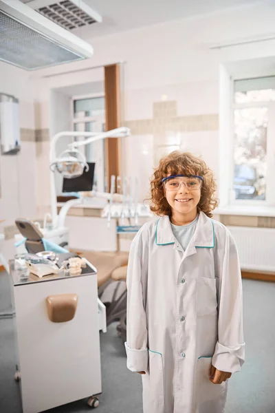 Smiley boy wearing lab technician uniform in a clinic — Stock Photo, Image