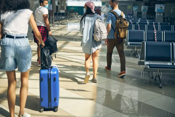 공항 강당을 걷고 있는 국제적 인 사람들의 그룹 — 스톡 사진