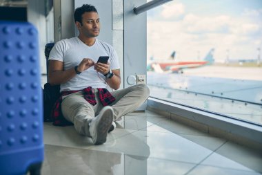 Nazik Hintli erkek cam panoramik pencerenin önünde vakit geçiriyor