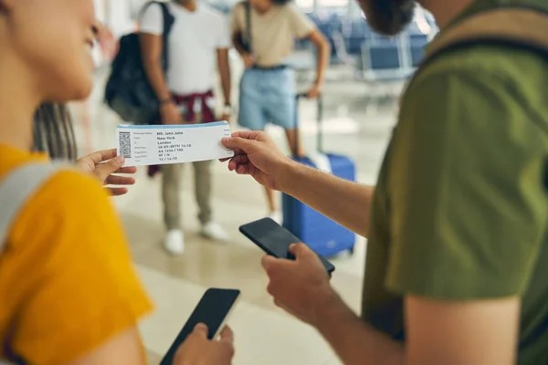 Hombre preguntando a una mujer sobre su billete de embarque en el aeropuerto — Foto de Stock