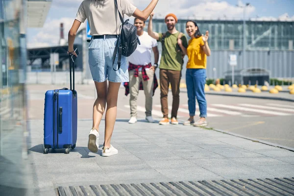 Amigos felices conociendo a mujer en aeropuerto — Foto de Stock