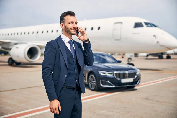 Businessman standing in front of an aircraft — Stock Photo, Image