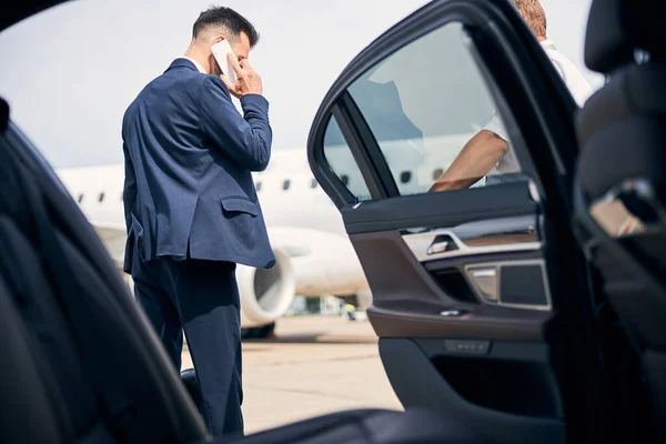 Mannen i kostym har ett telefonkiosk vid taxin — Stockfoto