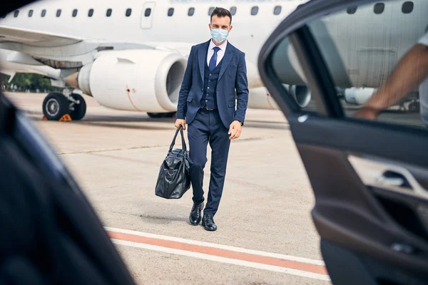 Joven emprendedor viajando con seguridad con una máscara puesta — Foto de Stock