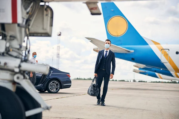 Moderne zakenman reist veilig met een masker op — Stockfoto