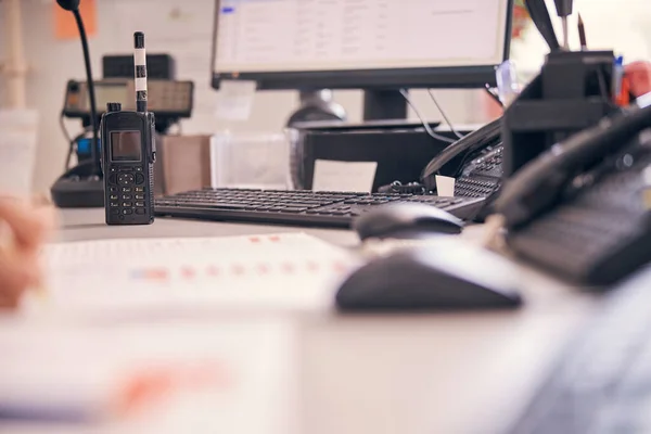 Walkie-talkie sitting on top of an office desk full of stationery