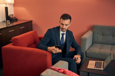 Sakin yakışıklı işadamı otel odasından çalışıyor.