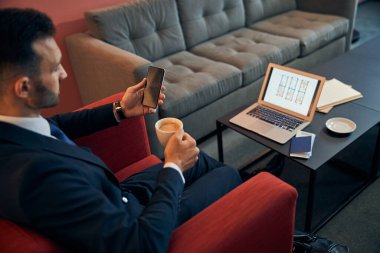 Modern aletleri olan bir iş adamı uçuşu bekliyor.