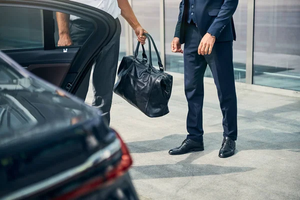 Motorista de táxi levando a bagagem de seu cliente — Fotografia de Stock