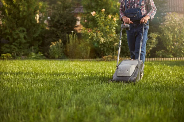 Jardinier prenant soin de sa pelouse à l'aide d'un coupe-herbe — Photo