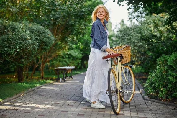 Ładna dorosła kobieta z rowerem na świeżym powietrzu — Zdjęcie stockowe