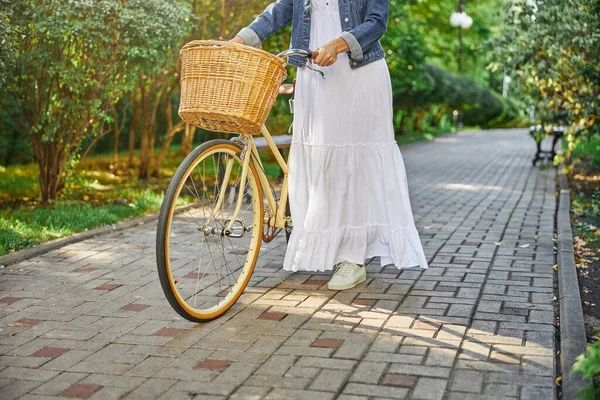 Hermosa mujer con bicicleta en el parque de la ciudad — Foto de Stock