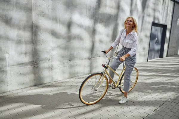 우아 한 평상복을 입고 자전거를 타기 시작하는 행복 한 백인 여성 — 스톡 사진