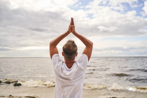 Tek başına deniz kıyısında yoga yapan bir adam. — Stok fotoğraf