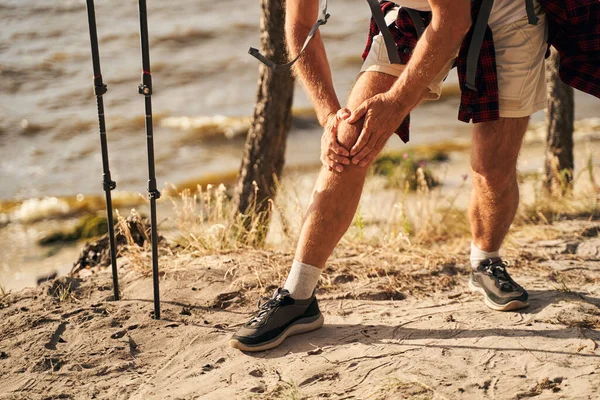 Man gekwetst been tijdens het nordic walking in de natuur — Stockfoto