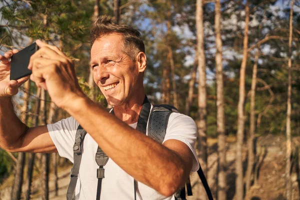 Gelukkige man neemt foto van prachtig uitzicht — Stockfoto