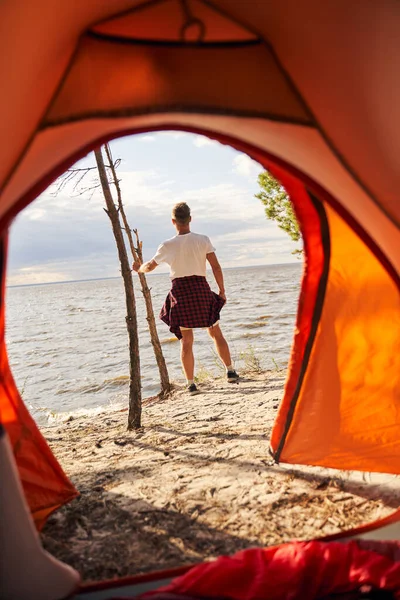 Uomo che va in campeggio in spiaggia soleggiata da solo — Foto Stock