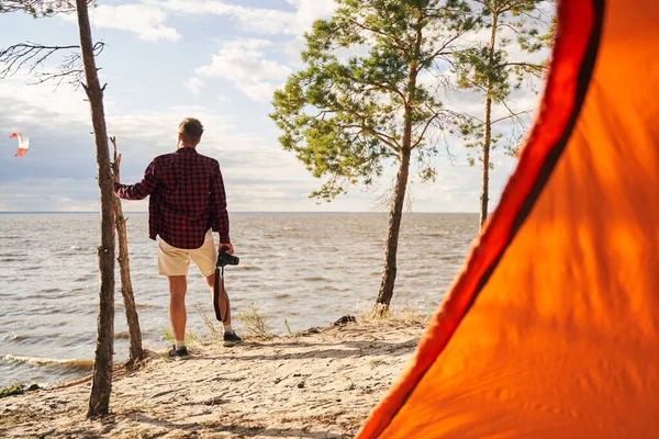 Man med digitalkamera kommer camping på stranden — Stockfoto