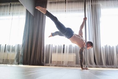 Çekici genç adam stüdyoda Pylon 'da dans ediyor.