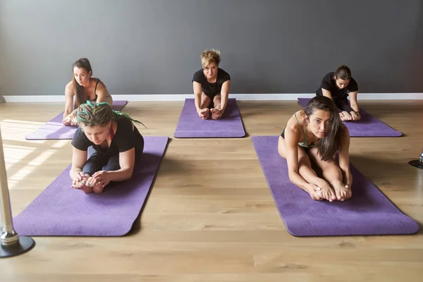 Atractivo grupo de entrenamiento están descansando después de hacer yoga juntos —  Fotos de Stock