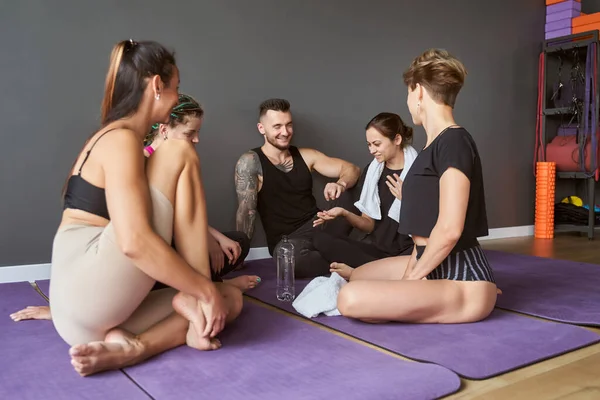 Istruttore di yoga che parla con il gruppo sportivo mentre trascorre del tempo in studio — Foto Stock