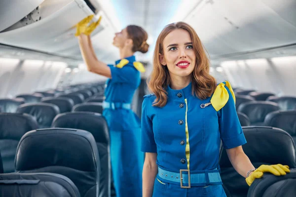 Women air hostesses in empty big commercial plane — Stock Photo, Image