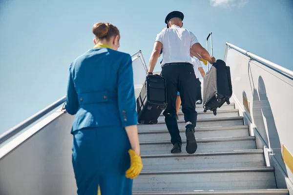 Bavullu pilot ve hostes uçağa biniyor. — Stok fotoğraf