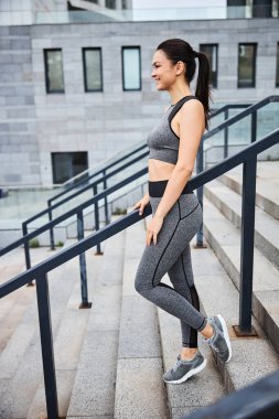 Mutlu atletik kadın şehir merkezinde egzersiz yapıyor.