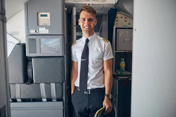 Cheerful capitão masculino de pé dentro do avião — Fotografia de Stock