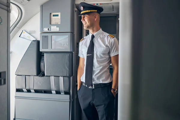 Schöner männlicher Kapitän steht im Verkehrsflugzeug — Stockfoto