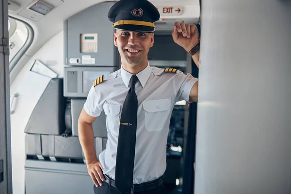 Capitão alegre do sexo masculino em pé dentro do avião comercial — Fotografia de Stock