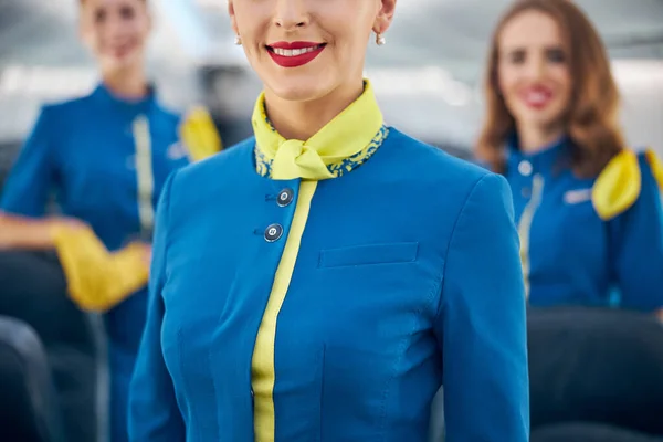 Affascinante donna che indossa tuta hostess aerea a bordo di aeroplano commerciale — Foto Stock