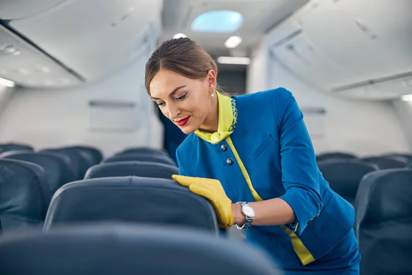 Charming female is checking modern international salon of passenger aircraft — Stock Photo, Image