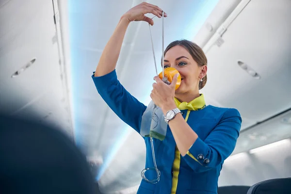 Letuška ukazuje, jak používat kyslíkovou masku na palubě — Stock fotografie