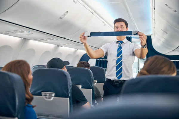 Handsome steward training veiligheid voorafgaande procedures voor het starten van de vlucht — Stockfoto