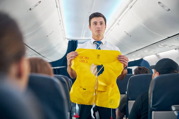 Steward démontrant les règles de sécurité de l'avion à bord — Photo