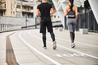 Genç atletik çift dışarıda spor yapıyor.