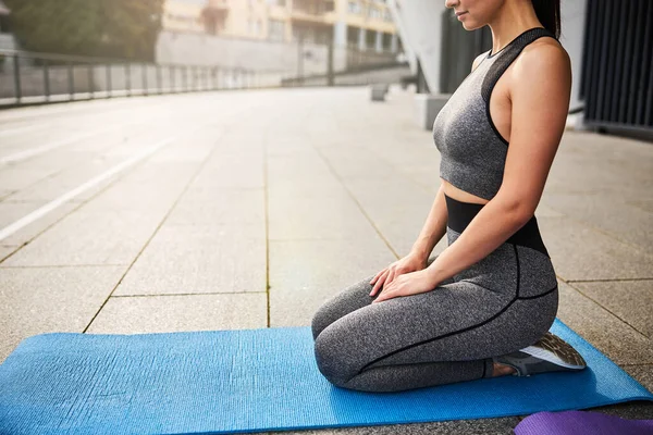 Sportif kadın şehir merkezinde meditasyon yapıyor. — Stok fotoğraf