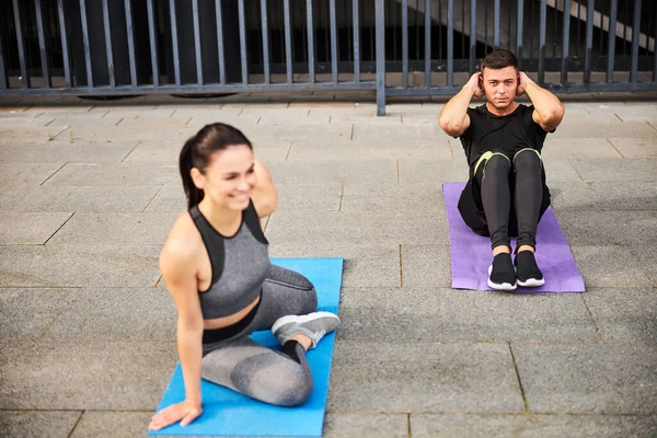 Jolly young couple doing sport together outdoors — Stock Photo, Image