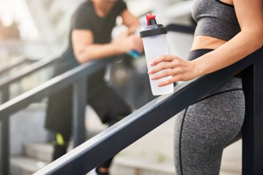 Açık hava eğitiminden sonra susuzluğunu gideren sportif çift.