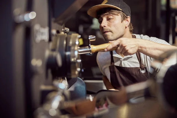 Tostador profesional usando máquina de tostado de café en fábrica — Foto de Stock