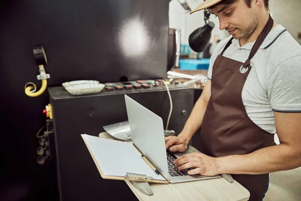 Handsome male worker using modern laptop at work — Stock Photo, Image