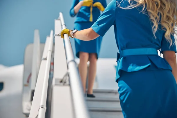 Two stewardesses standing on passenger airplane stairs — Stock Photo, Image