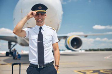 Hava alanında duran yakışıklı bir pilot.