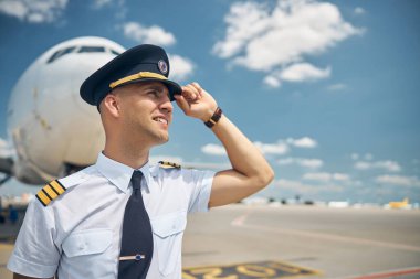 Havaalanında duran yakışıklı erkek pilot.