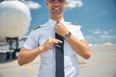Yakışıklı pilot havaalanında kravatını düzeltiyor.