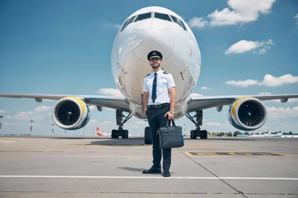 Vidám férfi pilóta áll a szabadban a repülőtéren — Stock Fotó