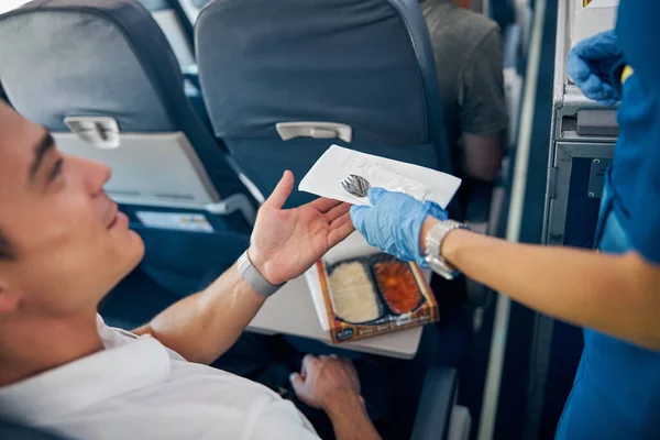 Пассажир, поедающий еду на борту коммерческого самолета — стоковое фото