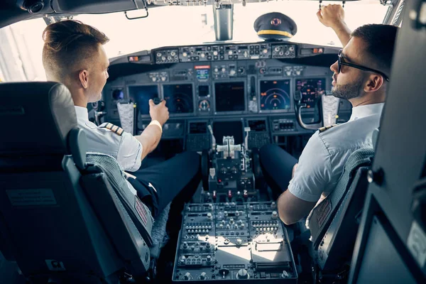 Twee knappe man zittend op de stoel in de cockpit — Stockfoto