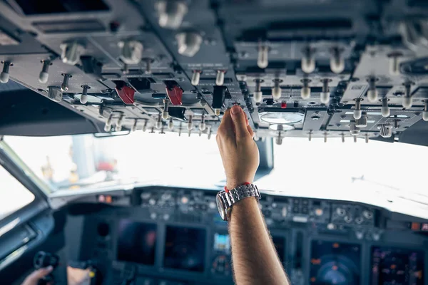 Pilot hand pushing on the dashboard in the aircraft — Stock Photo, Image